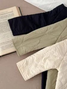 Close-up details of baby quilted rompers, soft wave pattern winter baby clothing texture.