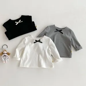 Kids long-sleeve tee detail, cute bow accent, soft ribbed knit fabric, three colors showcased.