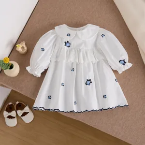 Abito bianco a maniche lunghe per neonata con ricamo floreale blu e delicato colletto in pizzo.
