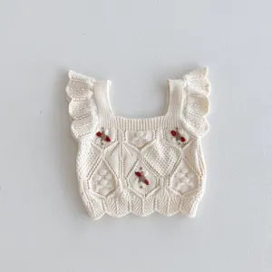 Close-up details of baby knit vest with cute ruffles, delicate embroidery and soft fabric.