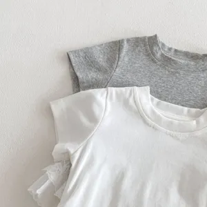 Gros plan detail des t-shirts manches courtes pour tout-petits avec dentelle fine.