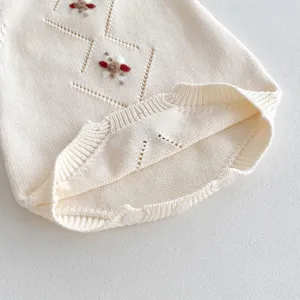 Cute baby knitted romper with handmade floral embroidery, soft cotton fabric, sweet style.