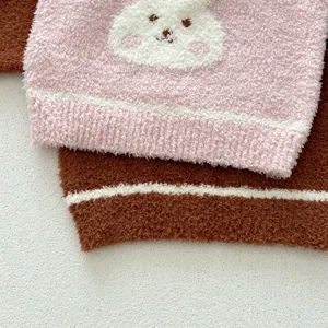 Close-up detail of fluffy baby home wear knit sweater, soft texture and cute rabbit pattern.