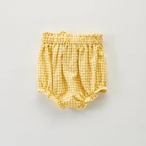 Détail de culotte bouffante à volants carreaux jaunes bébé, joli short d'été enfant.