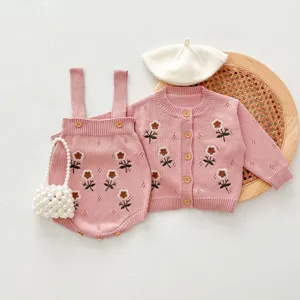 Dettaglio set cardigan in maglia e tutina neonata, ricamo floreale rosa, stile dolce.