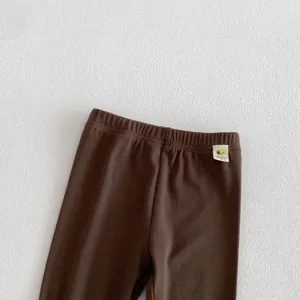 Détail de legging côtelé pour tout-petit, pantalon bébé marron, vêtement quotidien.