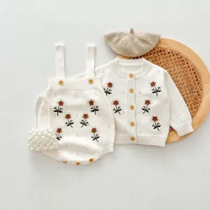 Vista di dettaglio del set cardigan e tutina lavorati a maglia per neonati con fiori.