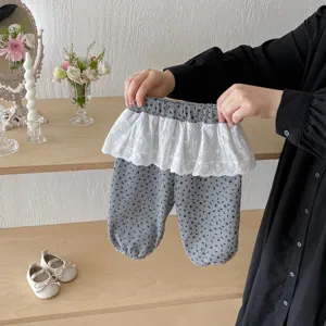 Toddler floral trousers with delicate lace skirt overlay, cute baby girl outfit detail shot.