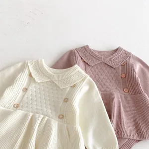 Detail shot of cute baby knitted romper dress with delicate collar, long sleeves, and buttons.