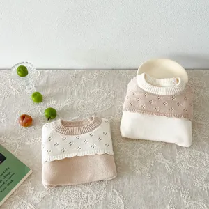 Vue detaillee du pull-over tricote pour bebe en coton doux, presentation de details.