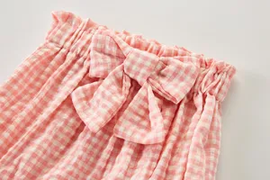 Gros plan détail short rose et blanc carreaux bambin taille élastique volantée nœud