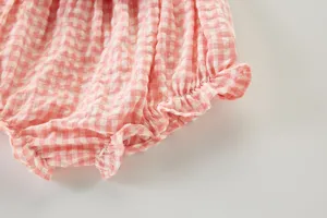 Gros plan détaillé de culotte bouffante bébé vichy rose et blanc à volants mignons.