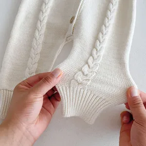 Close-up of baby cable knit romper fabric texture, soft cotton material detail shot.