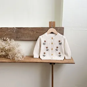 Delizioso cardigan in maglia per neonati con ricamo floreale, ideale per look autunnali.