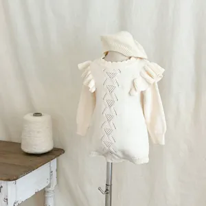 Set tutina e berretto in maglia color crema per neonata, con maniche a volant e design traforato.