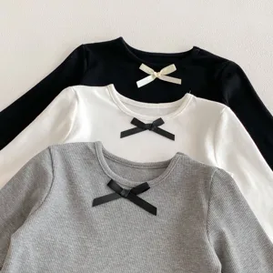 Detail shot of cute girls long sleeve bow t-shirt, soft ribbed fabric, versatile daily wear.