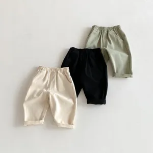 Detailansicht von Freizeithosen aus Baumwolle für Kinder in Beige, Schwarz und Grün.