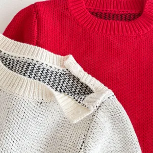 Close-up detail of baby knit romper collar with shoulder snap buttons and soft winter fabric.
