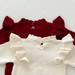 Vista dettagliata di un maglione per neonati in maglia con maniche a volant e tessuto morbido.