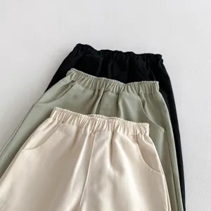 Nahaufnahme Detail der Freizeithose fuer Kinder, gestapelt mit elastischem Bund und Taschen.