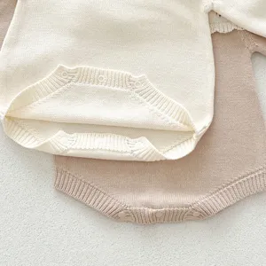 Gros plan détaillé d'un body bébé en tricot doux avec motif ajouré délicat et boutons-pression.