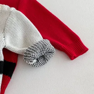 Knit baby romper detail shot, soft cotton woolen infant clothing texture close-up display.