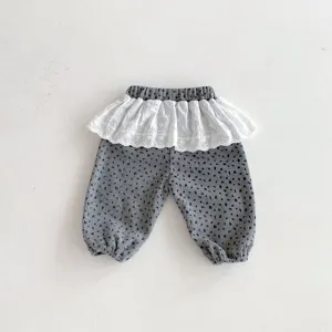 Detailed view of toddler floral corduroy pants with white lace frill hem and elastic waist.