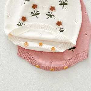 Bellissimo dettaglio di tutina per neonati in morbida maglia con delicato ricamo floreale.