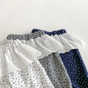 Close-up detail of toddler floral leggings featuring delicate lace ruffle waistbands and knit fabric.