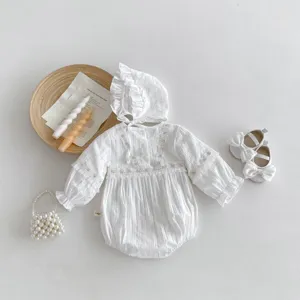 Vue à plat détaillée de la barboteuse bébé en dentelle blanche, bonnet et chaussures nœud.