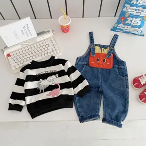 Detailansicht des Kinderbekleidungssets mit gestreiftem Dinosaurier-Sweatshirt und Latzhose.
