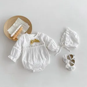 Ensemble barboteuse blanche pour bébé fille avec nœud et détails en dentelle, vue de détail.