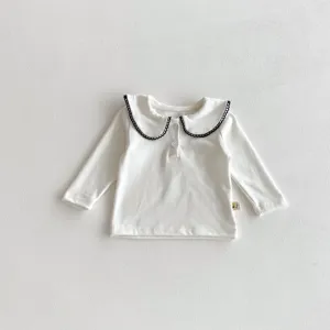 Baby white long sleeve top featuring a cute black scalloped collar and front button closure.