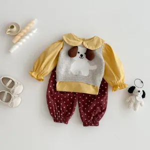 Cute toddler girl autumn outfit detail, yellow blouse, knit puppy vest and floral bloomers.
