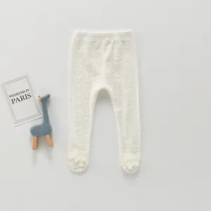 Détail de collants blancs pour bébé en tricot côtelé avec adorables fleurs sur les bas.