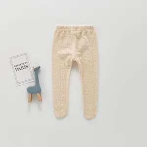 Jolis collants bébé beige en tricot torsadé. Vêtement confortable pour tout-petit en automne.