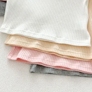 Close-up detail of soft ribbed cotton fabric stack in multiple colors for infant kids.