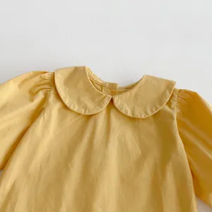 Detailed view of the cute yellow baby girls cotton top with Peter Pan collar and puff sleeves.