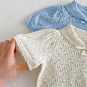 Close-up shot showing the delicate hollow-out knit texture and polo collar of the baby top.