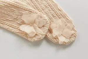 Vue détaillée de collants tricotés côtelés pour bébé avec délicates fleurs en tulle.