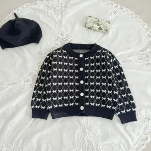Black and white knit cardigan detail, elegant diamond pattern and cute flower buttons style.