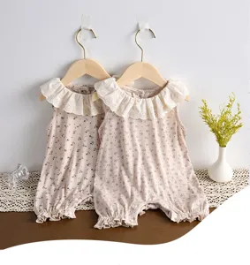 Close-up view of infant baby girl sleeveless floral romper with white eyelet lace collar.