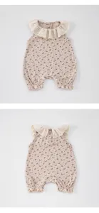 Detail view of baby girl sleeveless romper, floral rib knit fabric, cute white lace collar.