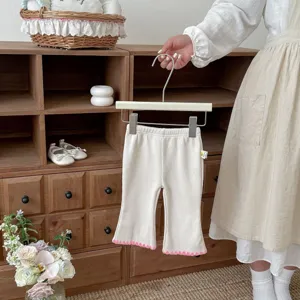 Detailansicht von gerippten Schlaghosen für Kleinkinder mit rosa welligem Saumabschluss.