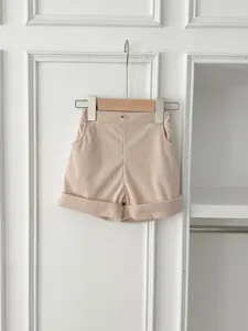 Baby corduroy shorts detail view, soft pink infant casual trousers, cute folded cuffs design.