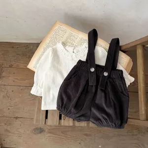 Infant baby corduroy suspender shorts and white ruffled blouse detailed flat lay shot.