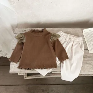 Detailed view of the baby autumn corduroy pants and ruffled long sleeve top set in vintage style.