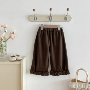 Vue détaillée de pantalon droit marron uni pour enfant avec ourlets à volants mignons.