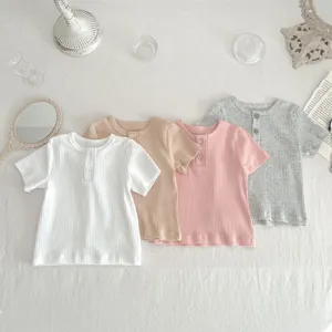 Dettagliato scatto flat lay di quattro magliette da neonato a coste con bottoncini.