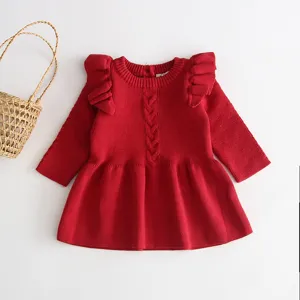 Red knitted baby girl dress detail showing cute shoulder ruffles and cozy cable knit pattern.